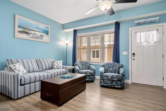 Open living room & kitchen with sleeper sofa, mounted smart TV, strong WiFi and fully-equipped kitchen