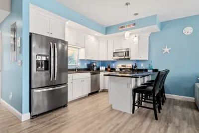 Open living room & kitchen with sleeper sofa, mounted smart TV, strong WiFi and fully-equipped kitchen