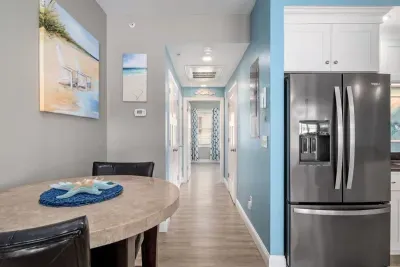 Open living room & kitchen with sleeper sofa, mounted smart TV, strong WiFi and fully-equipped kitchen