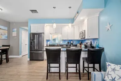 Open living room & kitchen with sleeper sofa, mounted smart TV, strong WiFi and fully-equipped kitchen
