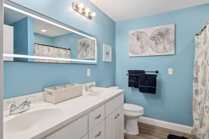 bedroom with ensuite bathroom with double sink, stand up shower and stackable washer & dryer