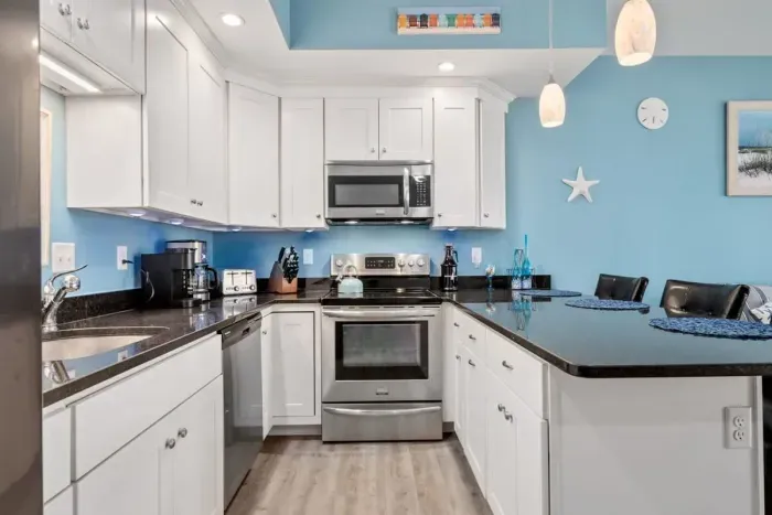 Open living room & kitchen with sleeper sofa, mounted smart TV, strong WiFi and fully-equipped kitchen