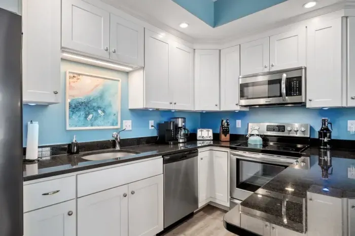 Open living room & kitchen with sleeper sofa, mounted smart TV, strong WiFi and fully-equipped kitchen