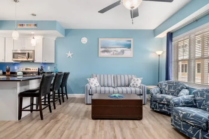 Open living room & kitchen with sleeper sofa, mounted smart TV, strong WiFi and fully-equipped kitchen