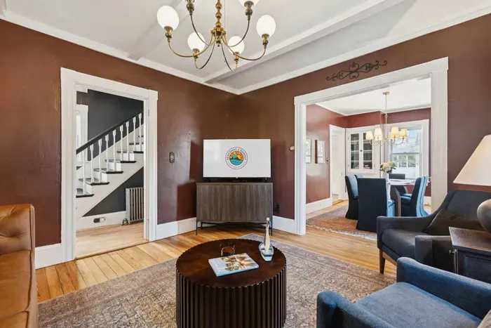 Living room with smart TV, a queen-sized sleeper sofa, and 2 comfy chairs