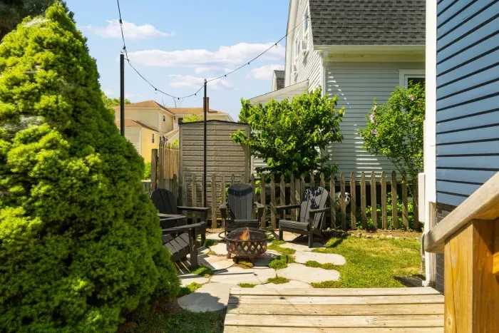 The backyard sitting area with string light, gas grill, and a wood burning fireplace!