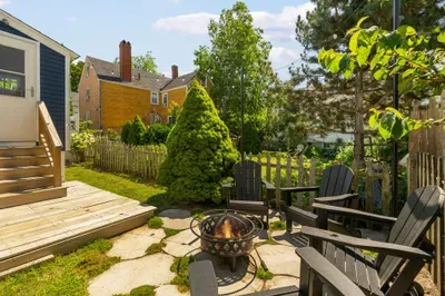 The backyard sitting area with string light, gas grill, and a wood burning fireplace!
