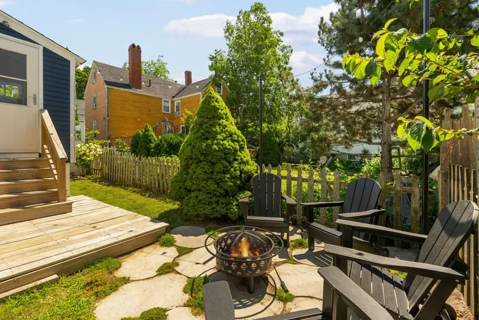 The backyard sitting area with string light, gas grill, and a wood burning fireplace!