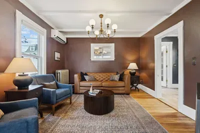 Living room with smart TV, a queen-sized sleeper sofa, and 2 comfy chairs