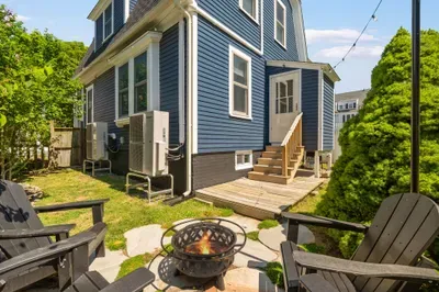 The backyard sitting area with string light, gas grill, and a wood burning fireplace!
