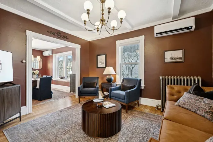 Living room with smart TV, a queen-sized sleeper sofa, and 2 comfy chairs