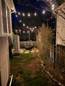 The backyard sitting area with string light, gas grill, and a wood burning fireplace!
