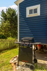 The backyard sitting area with string light, gas grill, and a wood burning fireplace!