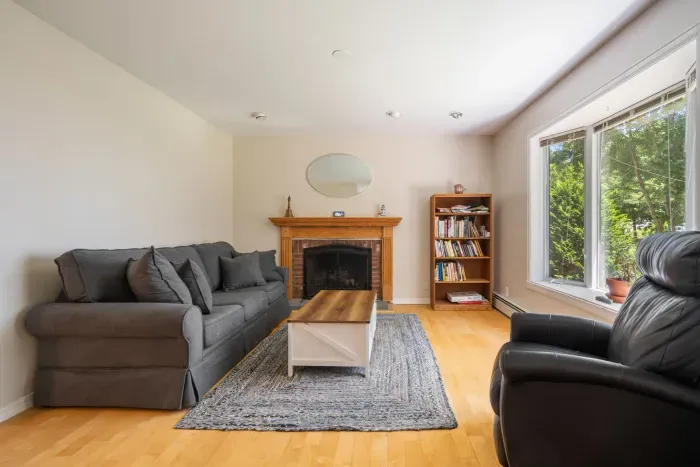 Den with full-sized sleeper sofa and recliner. Sleeper sofa looking out the widow at partial ocean views. Note - fireplace is inoperable