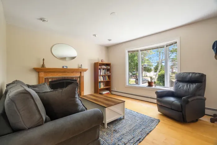 Den with full-sized sleeper sofa and recliner. Sleeper sofa looking out the widow at partial ocean views. Note - fireplace is inoperable
