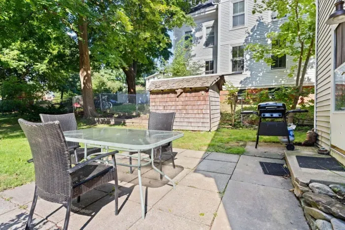 Roomy FENCED-IN backyard porch with grill, table and outdoor table.