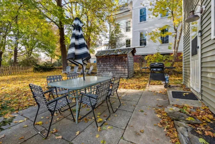 The back patio with a large fenced in yard and dining table