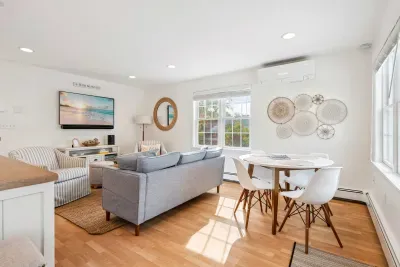 Living room with comfy couch, 2 chairs, and a large Smart TV