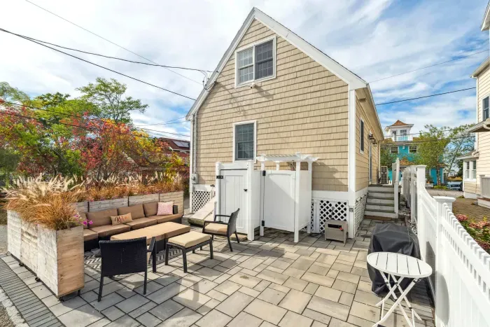 Back patio with a large sectional, grill, and outdoor shower.