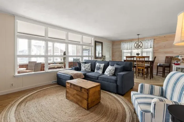 Open living room and fully-equipped kitchen, with dining room table, smart TV, and sleeper sofa.