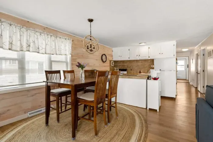 Open living room and fully-equipped kitchen, with dining room table, smart TV, and sleeper sofa.