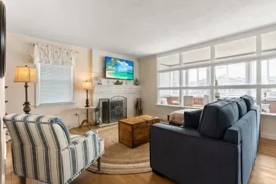 Open living room and fully-equipped kitchen, with dining room table, smart TV, and sleeper sofa.