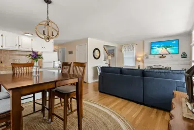 Open living room and fully-equipped kitchen, with dining room table, smart TV, and sleeper sofa.