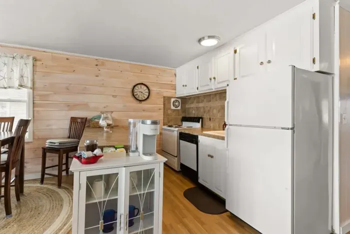 Open living room and fully-equipped kitchen, with dining room table, smart TV, and sleeper sofa.