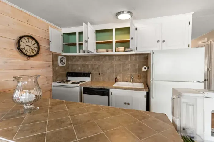 Open living room and fully-equipped kitchen, with dining room table, smart TV, and sleeper sofa.