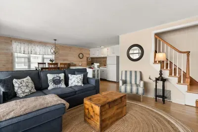Open living room and fully-equipped kitchen, with dining room table, smart TV, and sleeper sofa.