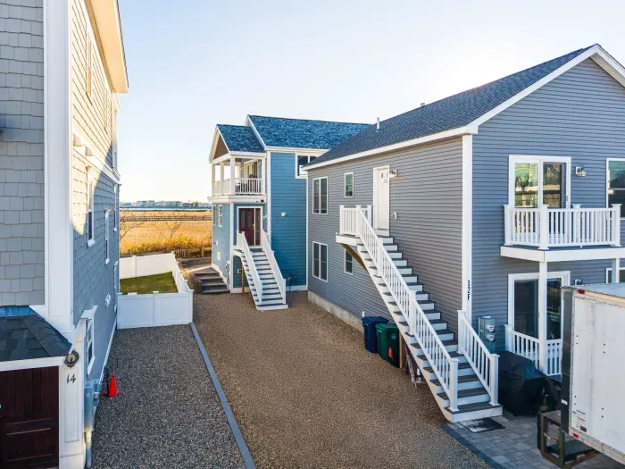 The tan gravel driveway fits 4 average cars. The back building is the home. This is the parking area for the home