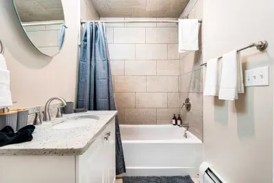 The second floor bathroom with tiled shower/tub combo! Clean towels are provided.