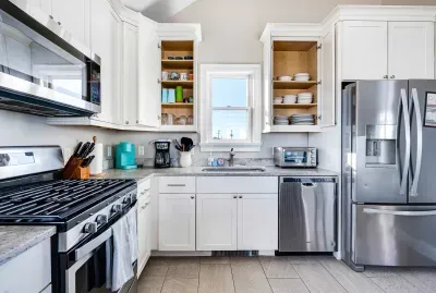 Fully equipped kitchen with basic cooking needs, utensils and plates.