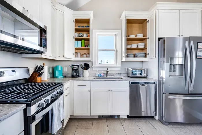 Fully equipped kitchen with basic cooking needs, utensils and plates. 