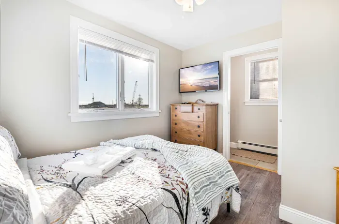 The primary bedroom! This room features a double bed, half bathroom, and a smart TV. There is a ceiling fan in this room as well. Clean linens and towels provided.