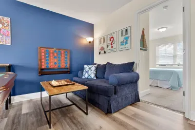 "The Game Room" features foosball, pool, wall-mounted connect 4, checkers, chess, dominoes, tic-tac-toe, a bar table with 3 stools, wall-mounted TV, slider leading to private balcony and a “work-from-home” desk