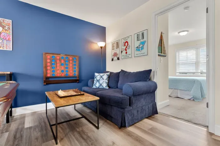 "The Game Room" features foosball, pool, wall-mounted connect 4, checkers, chess, dominoes, tic-tac-toe, a bar table with 3 stools, wall-mounted TV, slider leading to private balcony and a “work-from-home” desk