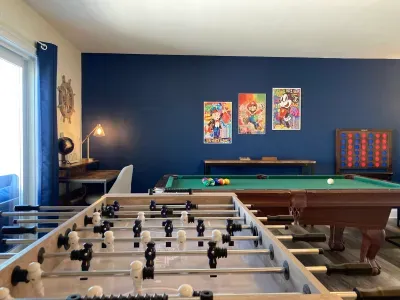 "The Game Room" features foosball, pool, wall-mounted connect 4, checkers, chess, dominoes, tic-tac-toe, a bar table with 3 stools, wall-mounted TV, slider leading to private balcony and a “work-from-home” desk