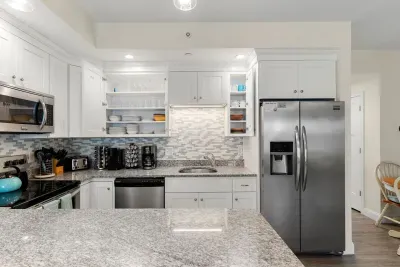 First floor living room and fully stocked kitchen, with flat screen smart TV, 4 barstools, reclining chair and kitchen table.