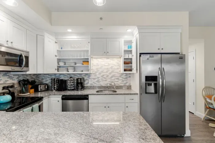 First floor living room and fully stocked kitchen, with flat screen smart TV, 4 barstools, reclining chair and kitchen table.