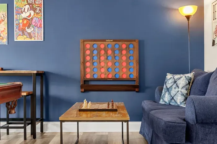 "The Game Room" features foosball, pool, wall-mounted connect 4, checkers, chess, dominoes, tic-tac-toe, a bar table with 3 stools, wall-mounted TV, slider leading to private balcony and a “work-from-home” desk