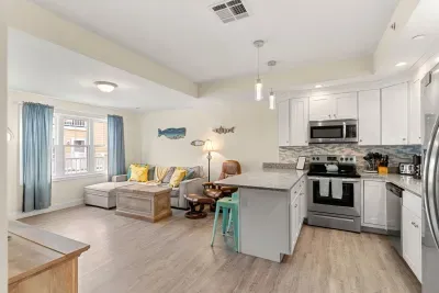 First floor living room and fully stocked kitchen, with flat screen smart TV, 4 barstools, reclining chair and kitchen table.
