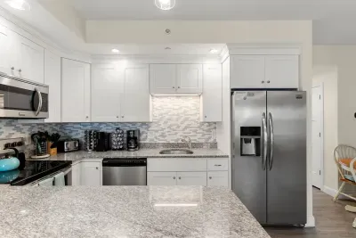 First floor living room and fully stocked kitchen, with flat screen smart TV, 4 barstools, reclining chair and kitchen table.