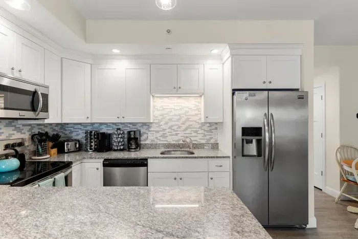 First floor living room and fully stocked kitchen, with flat screen smart TV, 4 barstools, reclining chair and kitchen table.