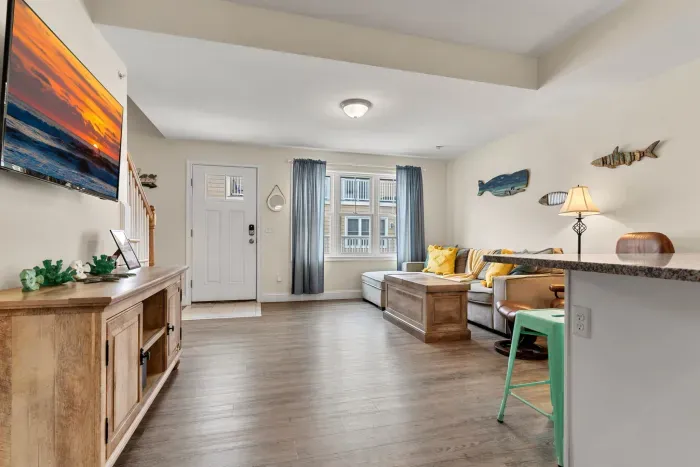 First floor living room and fully stocked kitchen, with flat screen smart TV, 4 barstools, reclining chair and kitchen table.