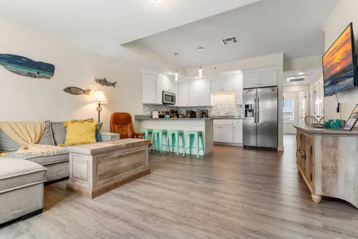 First floor living room and fully stocked kitchen, with flat screen smart TV, 4 barstools, reclining chair and kitchen table.