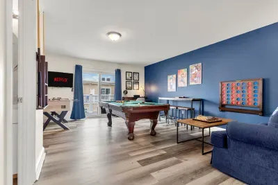"The Game Room" features foosball, pool, wall-mounted connect 4, checkers, chess, dominoes, tic-tac-toe, a bar table with 3 stools, wall-mounted TV, slider leading to private balcony and a “work-from-home” desk