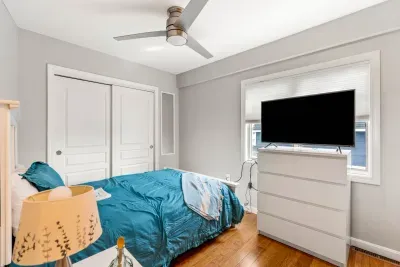 Queen bedroom with a smart TV and ceiling fan. Clean linens and towels provided for all guests