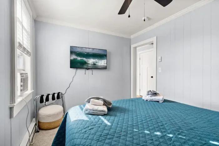 Bedroom #1 with queen bed, and mounted flatscreen smart Roku TV