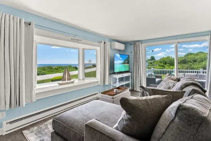 Open kitchen & living room with sleeper sofa, 50" smart TV, high-efficiency mini-split for AC/heat, and stunning views of the ocean.